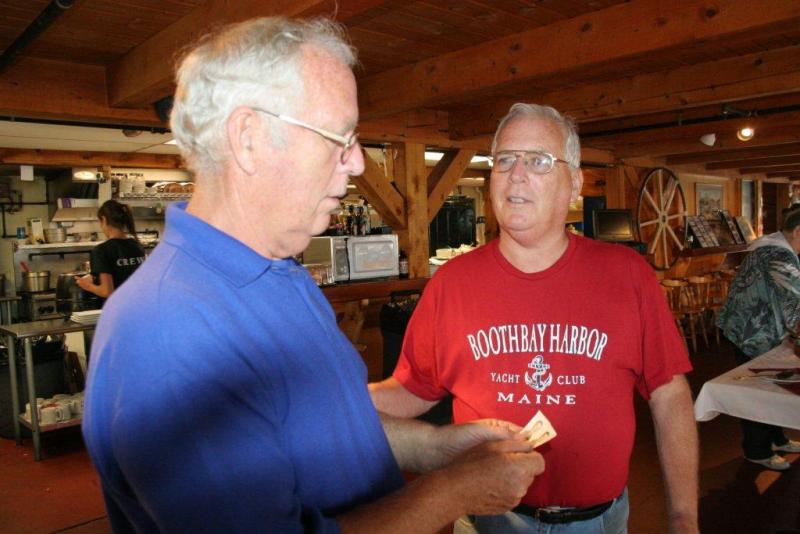 Dwight, left, and Duane Lewis look at the photos of themselves during their school days at the June 29 party at Robinson's Wharf. KEVIN BURNHAM/Boothbay Register